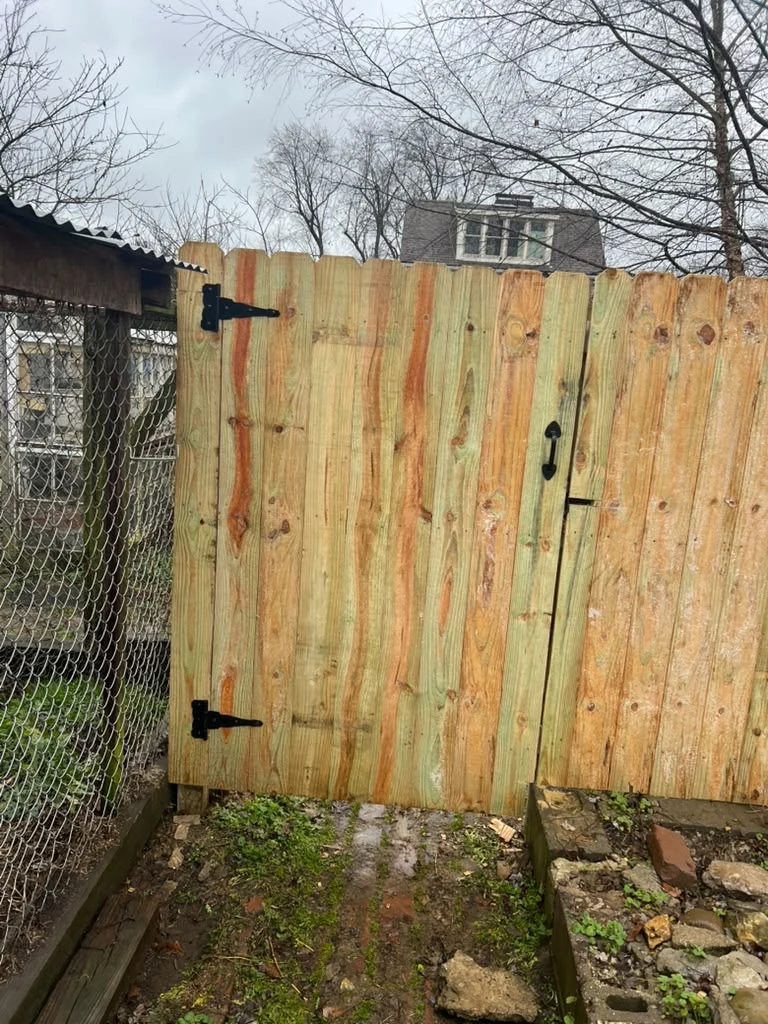 Wood gate beside an existing chain-link fence