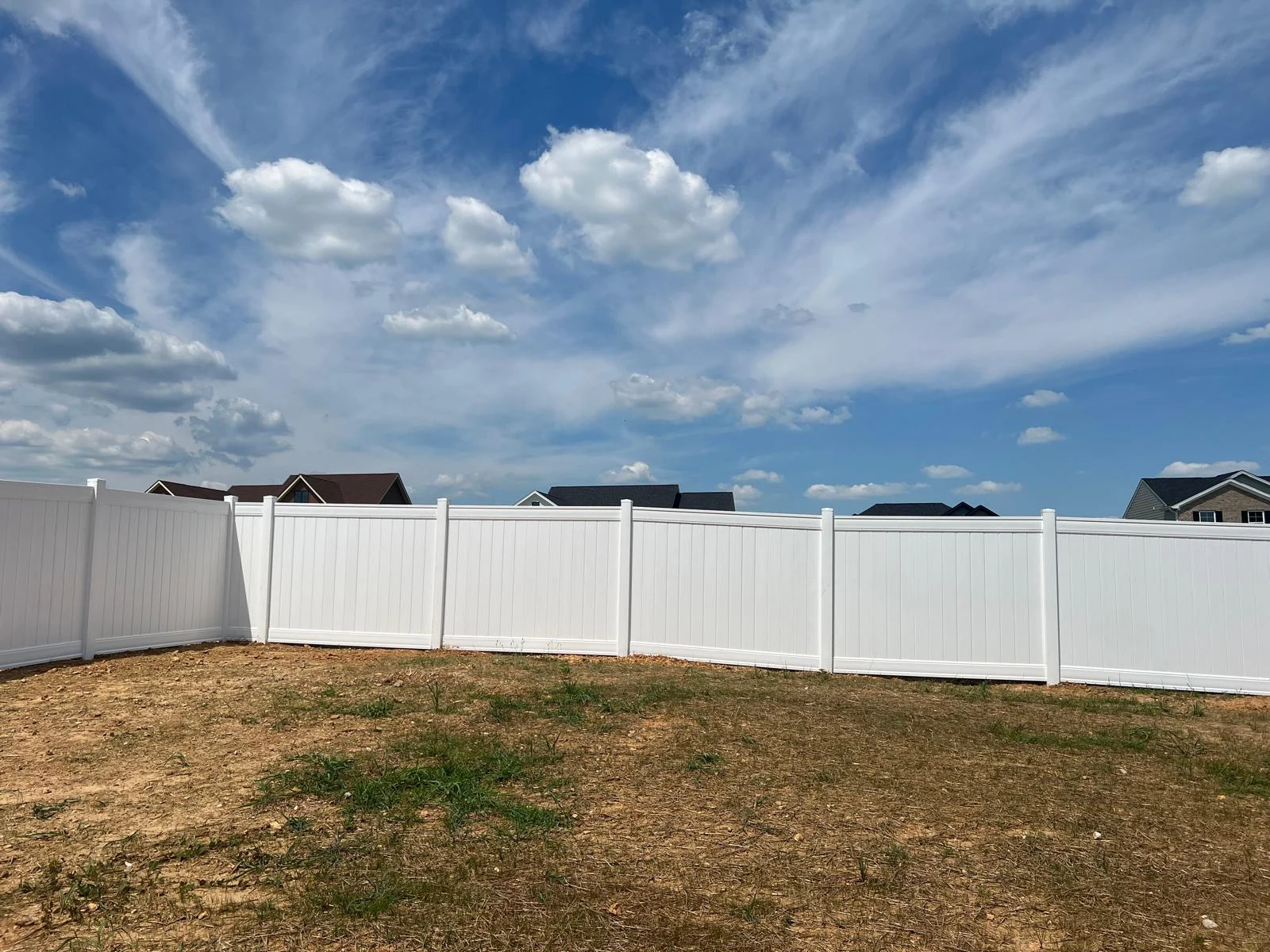 White privacy fence under a blue sky